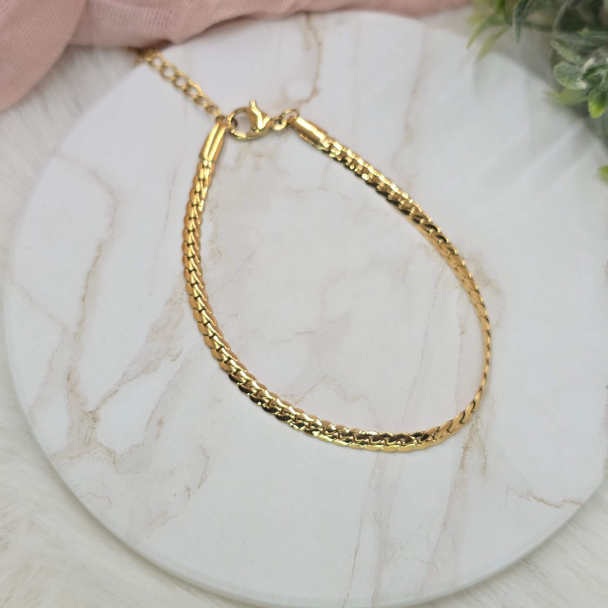 Gold bracelet on a marble surface
